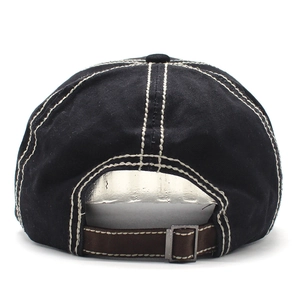 Detail of black cotton baseball cap showing white contrast stitching and adjustable strap