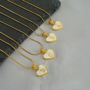 Detail of heart shell initial necklaces A-D on snake chain in gold and white finish