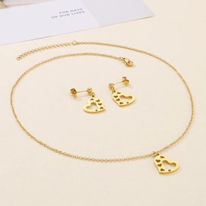 Detailed view of hollow heart necklace and earrings set in golden mirror finish