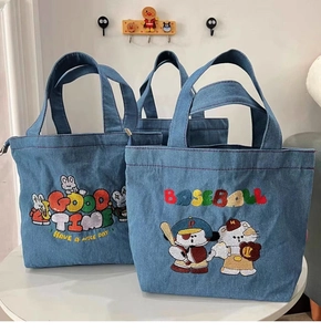 Detail of embroidered cartoon characters on two denim bucket bags with baseball theme