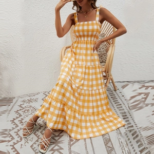 Detail of bohemian yellow striped dress featuring tiered skirt and ruched chest design