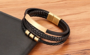 Close-up of men's multi-layer black braided leather bracelet with magnetic gold clasp