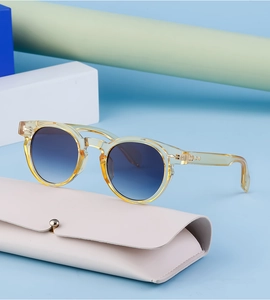 Detailed shot of yellow oval sunglasses with blue gradient lenses and pink leather case