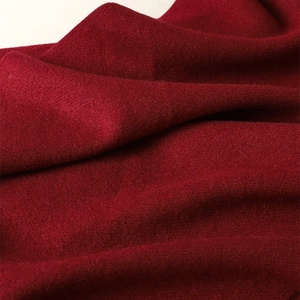 Close-up of soft burgundy cashmere-like fabric showing rich texture and weave details