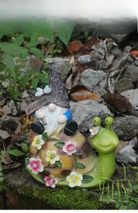 Detail of solar garden snail statue with gnome holding Welcome sign and LED flower lights