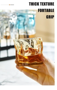 Close-up of thick textured whiskey glass showing a comfortable grip with amber liquid