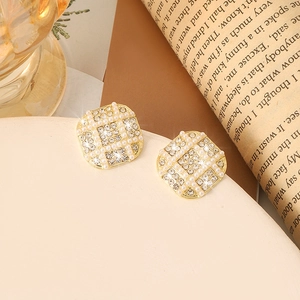 Elegant gold square stud earrings with inlaid pearls and rhinestones on vintage background