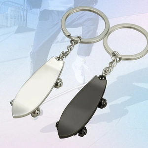 Miniature metal skateboard keychains in silver and black colors with a sporty urban design