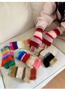 Détail de gants sans doigts en peluche rayée arc-en-ciel avec texture épaisse et douce