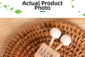 Detail of wooden aromatherapy clip for car vents on a woven tray with two diffuser sticks