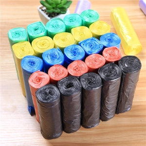 Thickened household flat-mouth trash bags in multiple vibrant colors on wooden surface