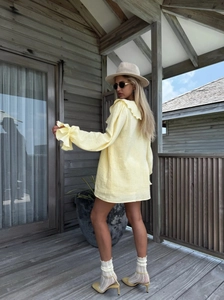 Détail du cardigan jaune à volants avec manches évasées et encolure plissée d'été