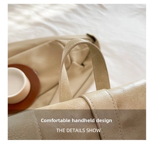 Close-up of dual-stitched handle detail on a beige vintage minimalist commute backpack