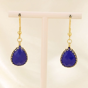 Gros plan de boucles d'oreilles goutte bleu marine facettées avec bordure dorée chic