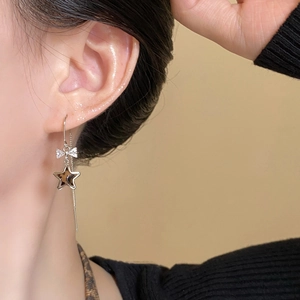 Macro shot of silver bow earrings with leopard print star pendant and sparkling rhinestones