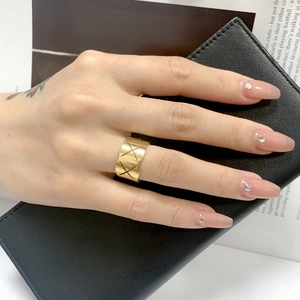 Fashionable gold wide ring with criss-cross quilted pattern worn by a model