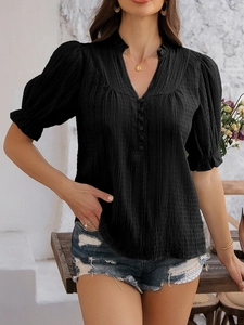 Detail view of black V-neck top with pleated texture and stylish flare puff sleeves