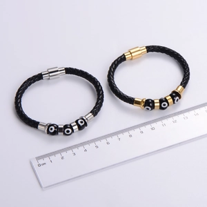 Close-up showing the size and magnetic clasp detail of the woven leather evil eye bracelet
