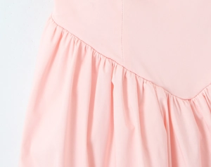 Macro shot of pink mesh dress fabric showing fine pleated details and clean stitching