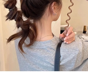 Detail of dark bubble phone line hair tie used in a stylish ponytail braid hairstyle