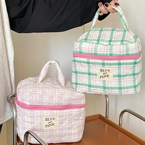 Detail of quilted cotton makeup bags with colorful check patterns and blue and pink labels