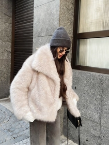 Detail of soft faux fur jacket with wide collar and plush texture in light beige