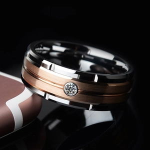 Close-up of silver and rose gold steel ring with brushed finish and inset crystal