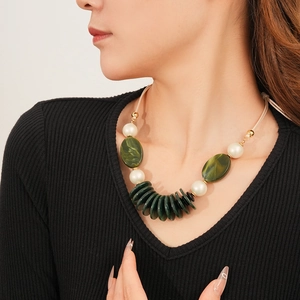 Detail of green flat beads and gold accents on a double-layer leather pendant necklace