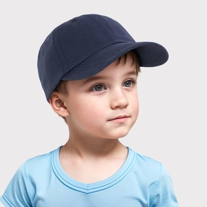 Detailed close-up of a navy blue cotton baseball cap worn by a young boy on a gray background