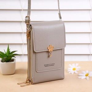 Detailed view of the grey cross-body mobile phone bag featuring dual zippers and floral charm