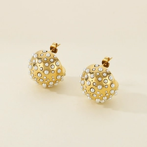 Macro shot of gold half-sphere earrings with white pearls and stainless steel studs
