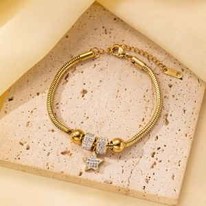 Primer plano detallado de pulsera de serpiente dorada con colgante de estrella y cuentas