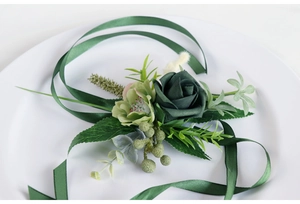 Close-up of deep green PE rose boutonniere with silk ribbon and eucalyptus leaves