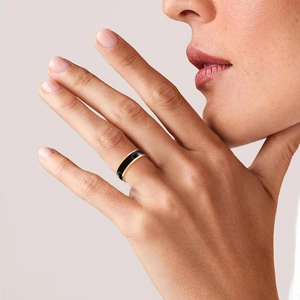 Minimalist black enamel ring with gold trim worn on finger, chic Korean style jewelry