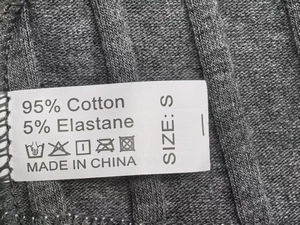 Macro detail of washing label showing 95% cotton material and size S on grey lace thong