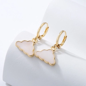 Detail of 18K gold plated hoop earrings with white enamel cloud charm on white podium