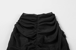 Detail of sheer black mesh fabric featuring intricate ruched texture and layering effect