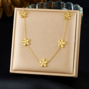 Elegant gold plated stainless steel necklace featuring five floral charms on a jewelry box