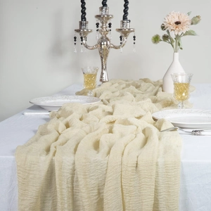 Close-up of beige cheesecloth table runner with natural wrinkles for wedding decor