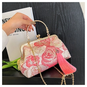 Close-up of red peony embroidery, golden kiss lock, and pink silk tassel on shell bag