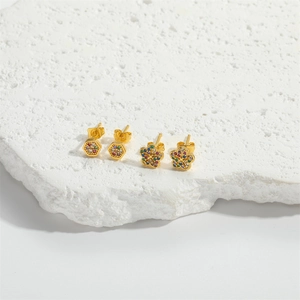 Macro detail of hexagonal and floral gold stud earrings with colorful cubic zirconia