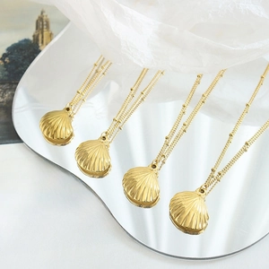 Elegant gold plated scallop shell pendant necklaces with satellite chains on mirror
