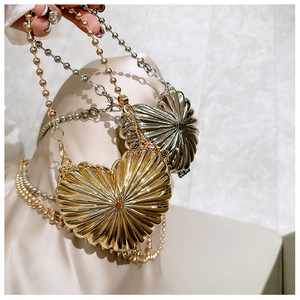 Detail of heart-shaped metallic shell bags in gold and silver with beaded chain straps