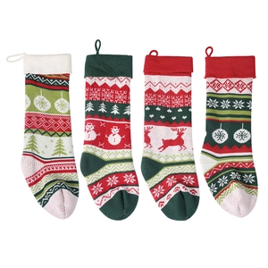 Set of four knitted Christmas stockings with snowman and reindeer patterns on white background