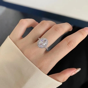 Close-up of S925 silver ring featuring a large oval halo diamond and pavé band