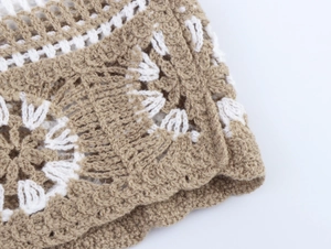 Detailed macro view of the beige and white crochet knit texture and geometric pattern