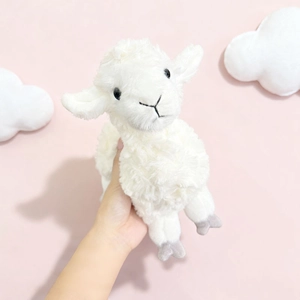 Cute white stuffed sheep plush toy with curly wool texture on a soft pink background