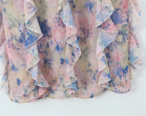 Detailed view of colorful floral print chiffon fabric with layered ruffle hem decoration