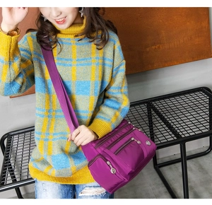 Detail view of purple waterproof nylon crossbody bag with multiple zip compartments