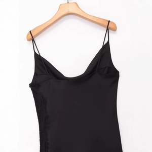 Robe nuisette élégante en satin noir avec dentelle délicate sur un cintre en bois